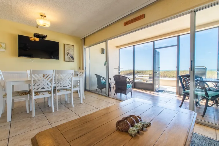 Open living and dining area with tile floors and sliding glass doors facing the Gulf. for Casa Del Mar Unit A03 on Longboat Key