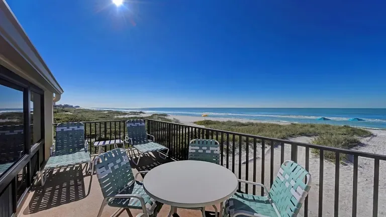 Unit A09 patio with a round table and chairs overlooking the beach dunes and Gulf. for Casa Del Mar Unit A09 on Longboat Key